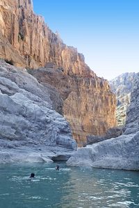Randonneurs nageant dans une vasque naturelle dans le canyon du Wadi bani Khalid.